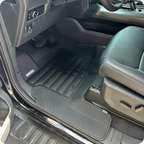 Car interior with gray floor mats and leather seats.