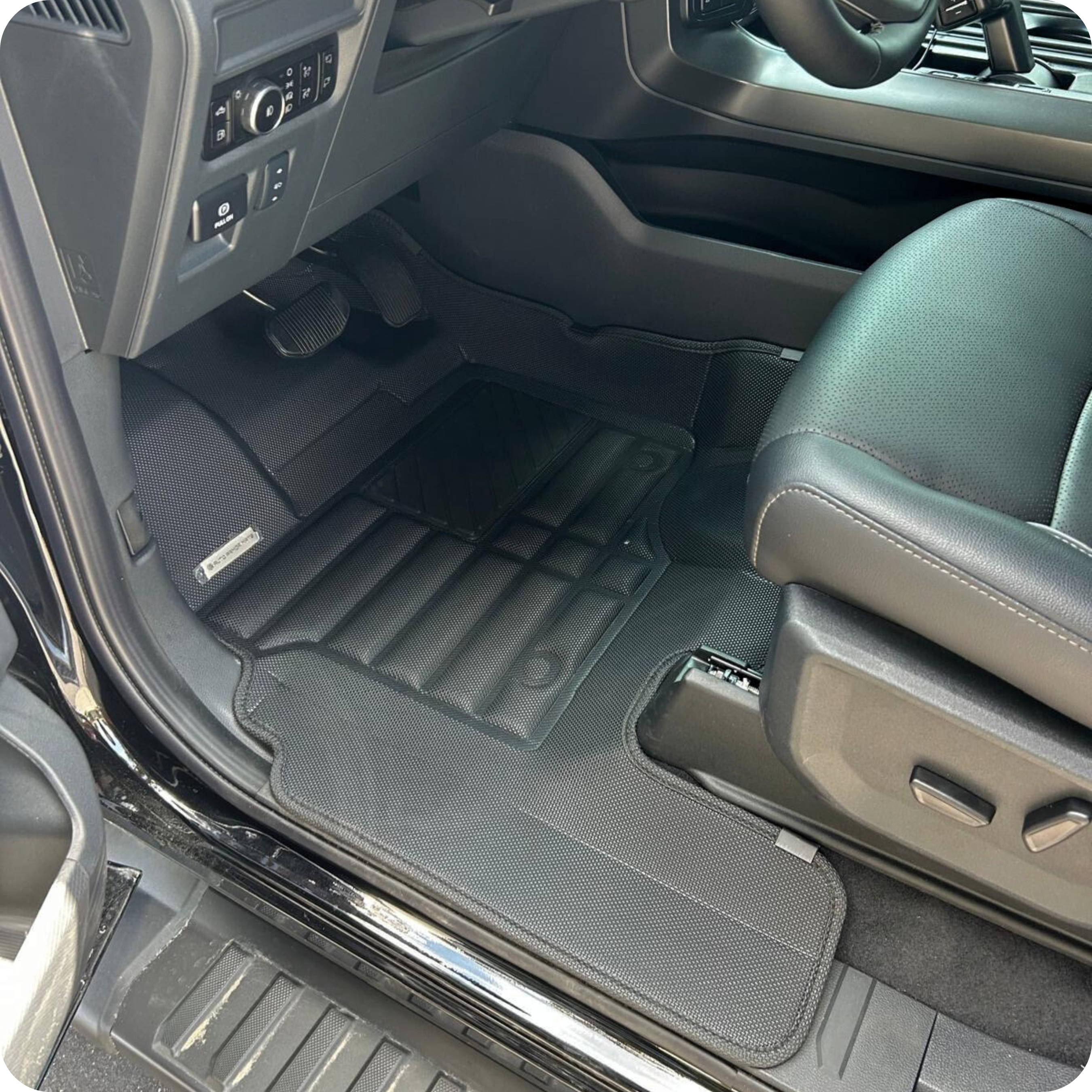Car interior with gray floor mats and leather seats.